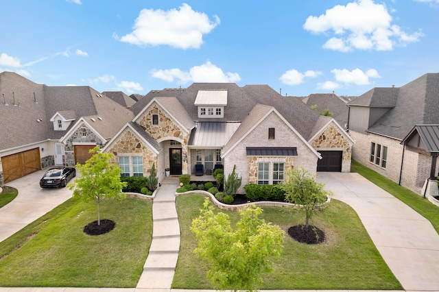 view of front of house featuring a front yard, a standing seam roof, driveway, and stone siding