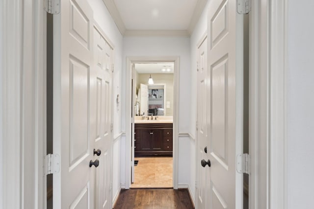 hall featuring ornamental molding, dark wood-style flooring, and a sink