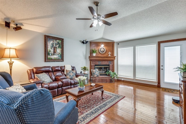 1916 Overland St, Fort Worth, TX 76131 - living room featuring vaulted ceiling, ceiling fan, a textured ceiling, hardwood / wood-style floors, and a fireplace