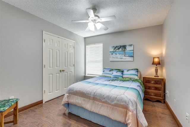 bedroom featuring baseboards, wood finished floors, a textured ceiling, and a closet