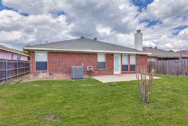 rear view of house with a fenced backyard, brick siding, a patio area, cooling unit, and a lawn