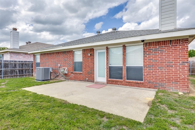 rear view of property with fence, cooling unit, a lawn, and brick siding