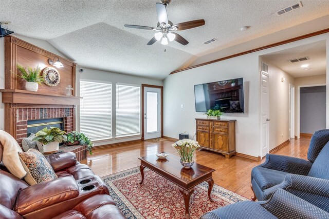living room featuring lofted ceiling, visible vents, and light wood-type flooring