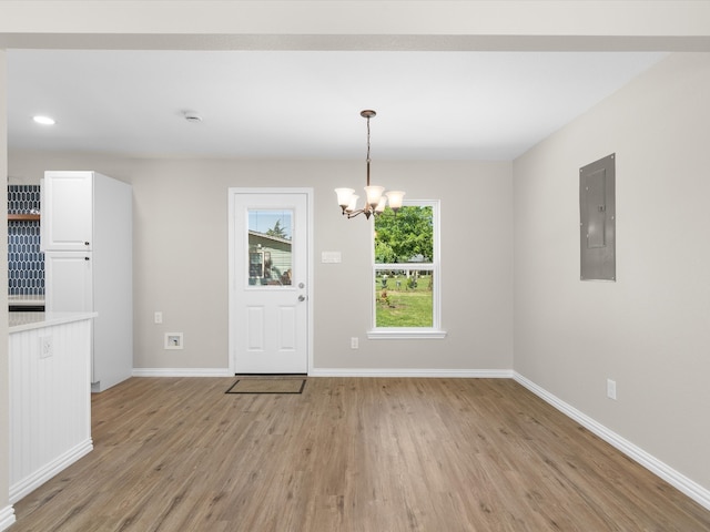 4451 Hardy St, Fort Worth, TX 76106 - unfurnished dining area featuring light wood-style flooring, a chandelier, electric panel, and baseboards