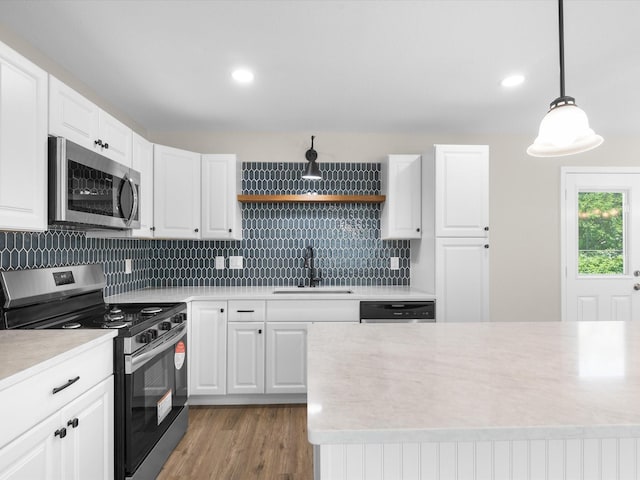 4451 Hardy St, Fort Worth, TX 76106 - kitchen with tasteful backsplash, a sink, appliances with stainless steel finishes, light countertops, and light wood finished floors