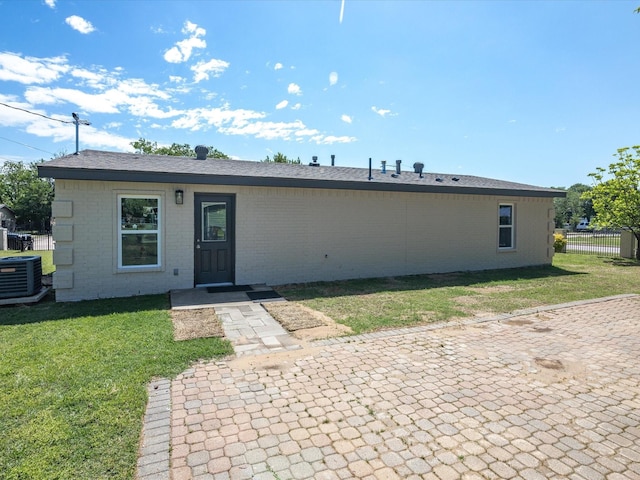 4451 Hardy St, Fort Worth, TX 76106 - view of front of property with brick siding, fence, central air condition unit, a patio, and a front lawn