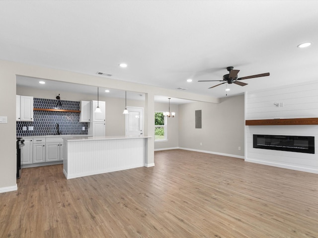4451 Hardy St, Fort Worth, TX 76106 - unfurnished living room with light wood finished floors, ceiling fan with notable chandelier, visible vents, and a fireplace