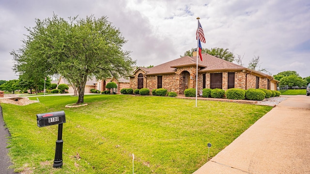 single story home with brick siding, a shingled roof, and a front yard
