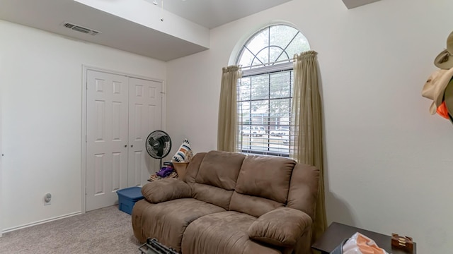 sitting room featuring visible vents, a ceiling fan, and light colored carpet