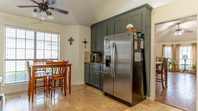 kitchen with gray cabinets, ceiling fan, vaulted ceiling, baseboards, and stainless steel fridge with ice dispenser
