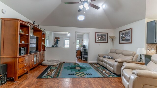living room featuring a ceiling fan, vaulted ceiling, wood finished floors, and baseboards