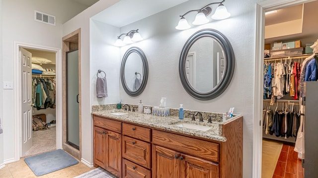 bathroom featuring a sink, double vanity, visible vents, and a spacious closet