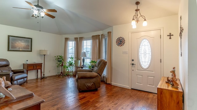 foyer entrance with wood finished floors, a ceiling fan, vaulted ceiling, and baseboards