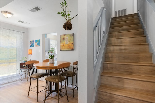 dining room featuring visible vents, wood finished floors, and stairway