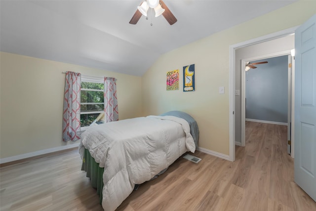 bedroom with lofted ceiling, visible vents, ceiling fan, baseboards, and light wood finished floors