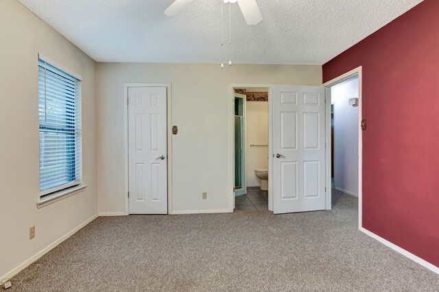 unfurnished bedroom featuring carpet, a textured ceiling, and baseboards