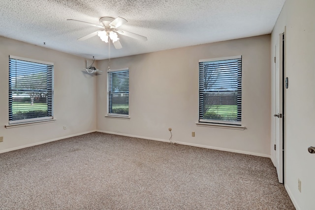 empty room with plenty of natural light, a ceiling fan, and carpet floors