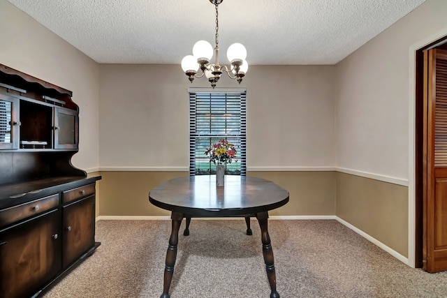 carpeted dining area featuring an inviting chandelier, a textured ceiling, and baseboards