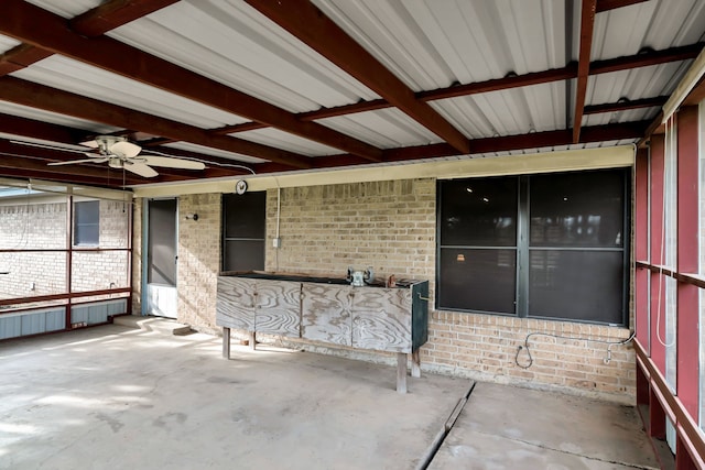 unfurnished sunroom featuring a ceiling fan