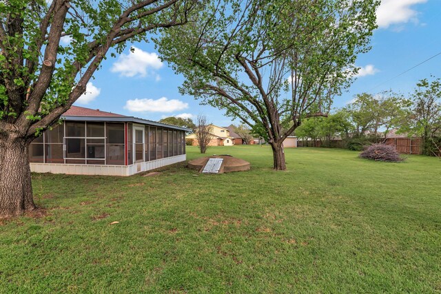 view of yard with fence and a sunroom