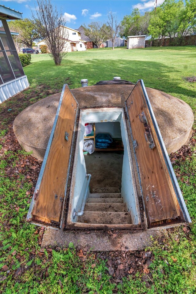 entry to storm shelter featuring a lawn