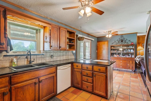kitchen featuring a sink, a peninsula, dishwasher, and brown cabinets