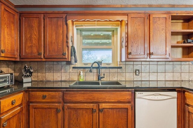 kitchen with brown cabinetry, dark countertops, dishwasher, and a sink