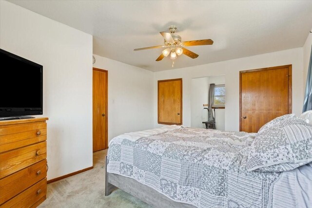 bedroom featuring ceiling fan, light carpet, and baseboards