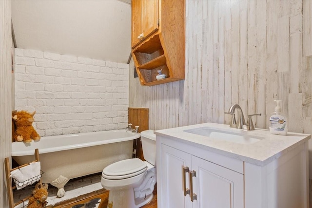full bath featuring toilet, a freestanding tub, and vanity