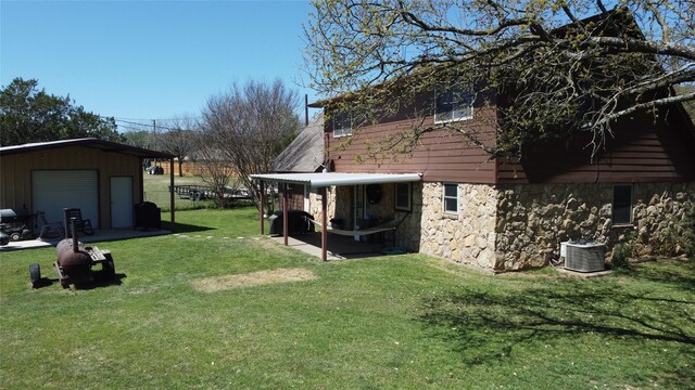 view of yard with an outbuilding, cooling unit, and a garage