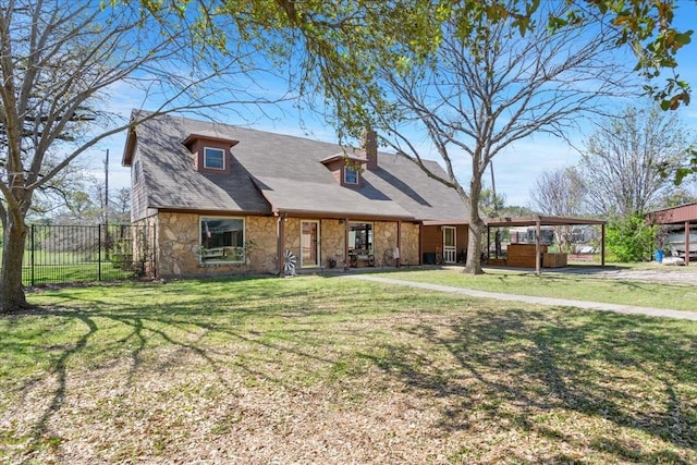 view of front of home with fence, a detached carport, a front lawn, and stone siding