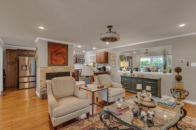 living area featuring crown molding, recessed lighting, baseboards, and light wood-type flooring