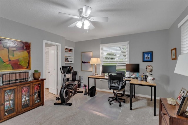 carpeted home office with a ceiling fan