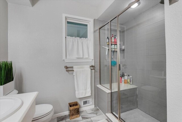 bathroom with toilet, visible vents, a shower stall, and baseboards