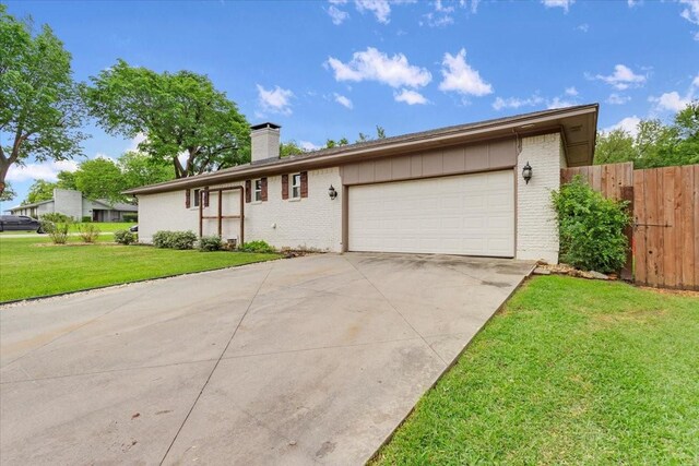 ranch-style home with fence, a chimney, brick siding, and a garage