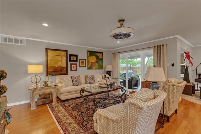 living room with recessed lighting, ornamental molding, light wood-type flooring, baseboards, and visible vents