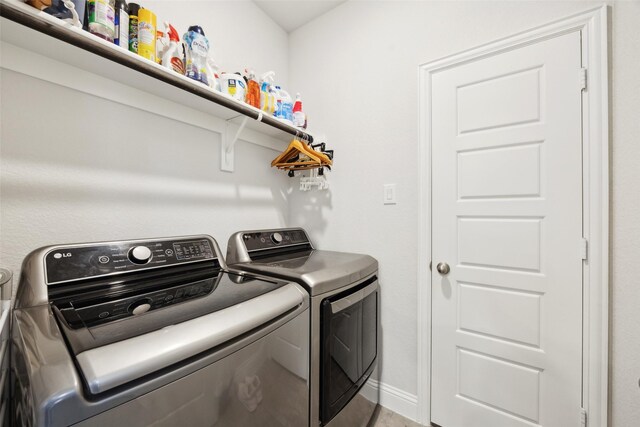 washroom featuring baseboards, laundry area, and washing machine and dryer