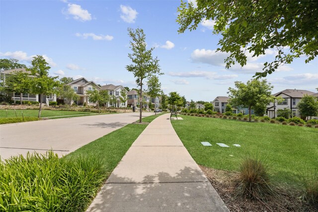 view of property's community with a residential view and a lawn