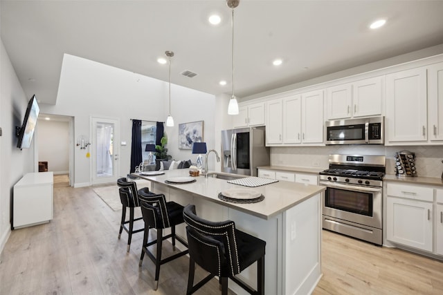 kitchen featuring a sink, visible vents, white cabinets, and stainless steel appliances