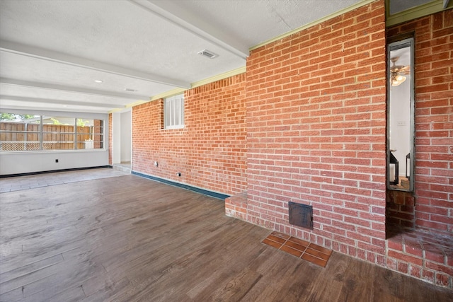 5816 Sandra Dr, Fort Worth, TX 76133 - interior space featuring beam ceiling, brick wall, baseboards, wood finished floors, and visible vents