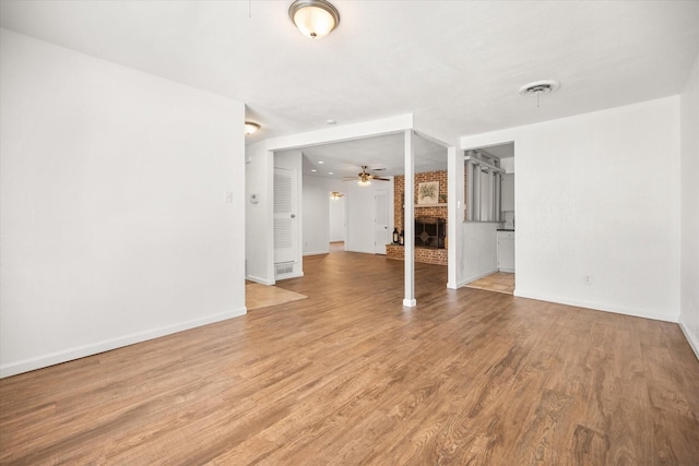 5816 Sandra Dr, Fort Worth, TX 76133 - unfurnished living room featuring ceiling fan, light wood-style floors, a brick fireplace, baseboards, and visible vents
