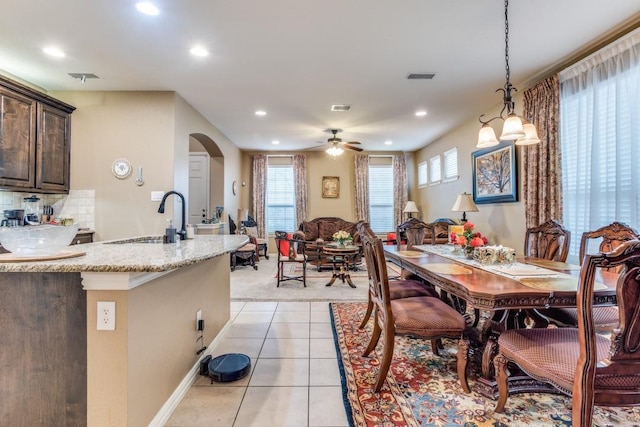 dining area with recessed lighting, light tile patterned floors, a ceiling fan, and arched walkways