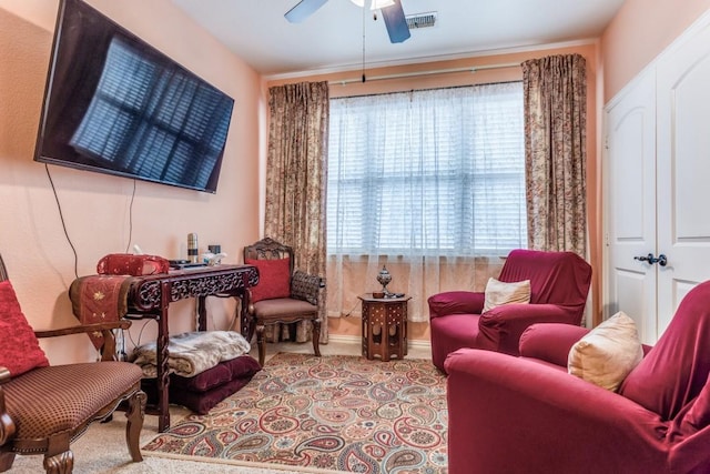 sitting room with visible vents, a ceiling fan, baseboards, and carpet floors