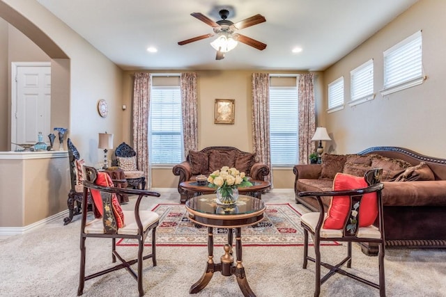 carpeted living room featuring ceiling fan, recessed lighting, baseboards, and arched walkways