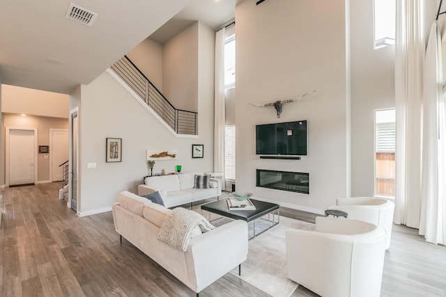 3901 Campania Ct, Colleyville, TX 76034 - living room featuring stairway, visible vents, baseboards, wood finished floors, and a high ceiling