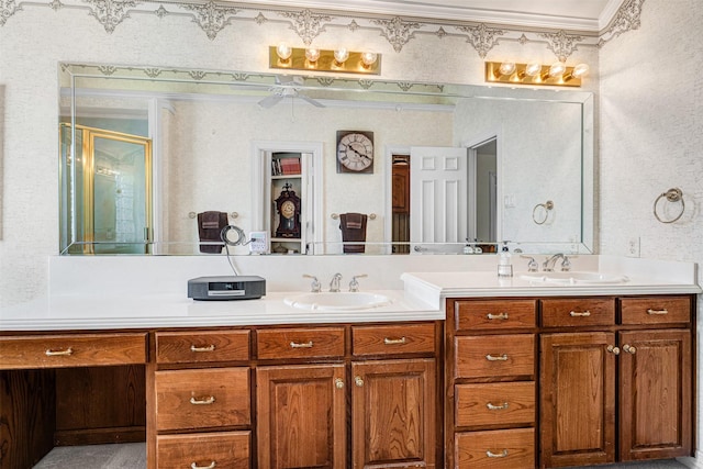 bathroom featuring double vanity, a sink, a shower with door, and crown molding