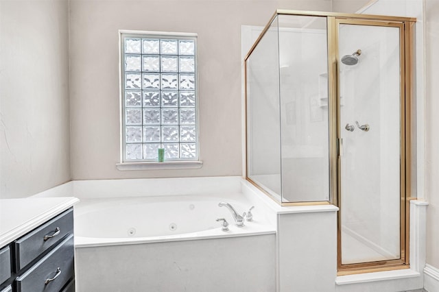 bathroom featuring a tub with jets, plenty of natural light, a shower stall, and vanity