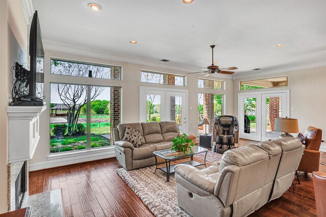 living area featuring french doors, ornamental molding, a ceiling fan, and dark wood-type flooring
