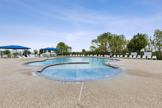 pool featuring fence and a patio area