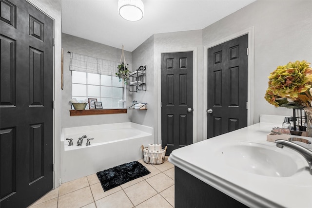 full bathroom featuring a garden tub, tile patterned flooring, and a sink